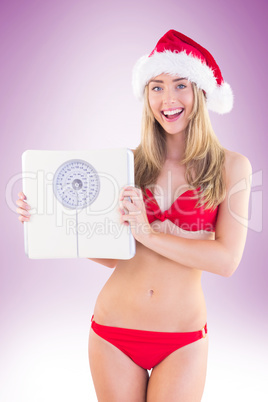 Festive fit blonde in red bikini showing scales