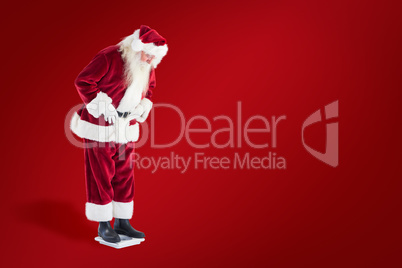 Composite image of santa looks down to personal scales