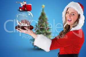 Composite image of sexy santa girl holding snow globe