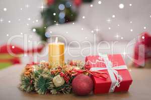 Composite image of candle and wreath on table for christmas