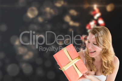 Composite image of cute blonde holding a gift