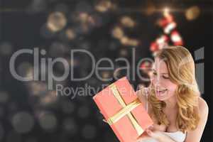 Composite image of cute blonde holding a gift