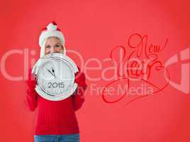 Composite image of happy festive blonde with clock