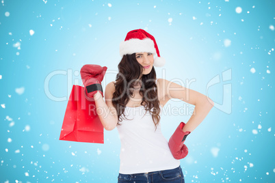 Composite image of beauty brunette in boxing gloves with shoppin