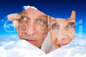 Composite image of older couple looking through rip