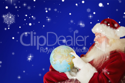 Composite image of father christmas pointing to globe