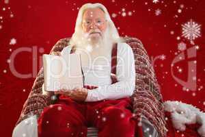 Composite image of father christmas showing a book