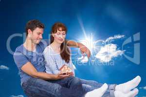 Composite image of couple using tablet at home