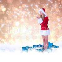 Pretty santa girl blowing over hands