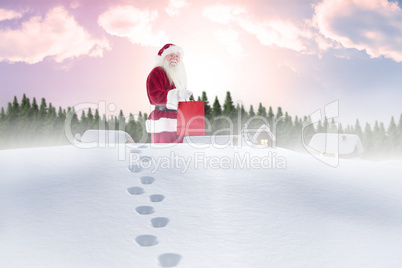 Composite image of santa carrying gifts in the snow