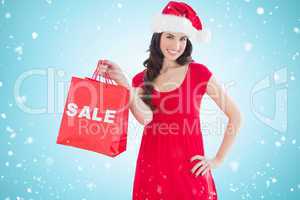 Composite image of festive brunette holding sale bag