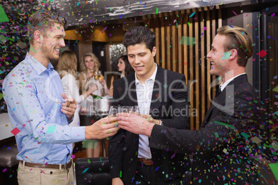 Composite image of handsome friends having a drink together