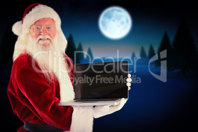 Composite image of santa claus presents a laptop