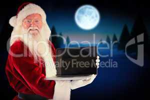 Composite image of santa claus presents a laptop