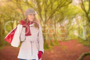 Composite image of happy blonde in winter clothes with bags