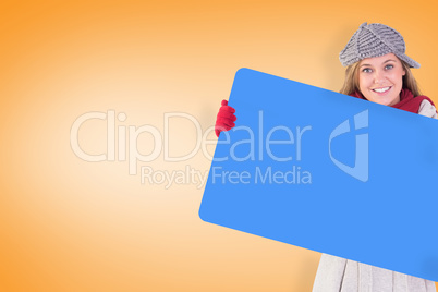 Composite image of happy blonde in winter clothes showing card