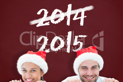 Composite image of festive young couple smiling at camera Composite image of festive young couple smiling at camera