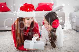 Composite image of festive mother and daughter opening a christm