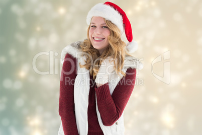 Composite image of blonde in santa hat smiling at camera