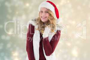 Composite image of blonde in santa hat smiling at camera