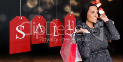 Composite image of smiling woman holding shopping bag