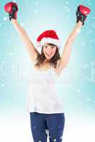 Composite image of festive brunette cheering with boxing gloves