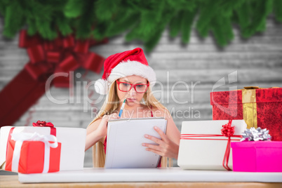 Composite image of festive blonde writing her christmas list