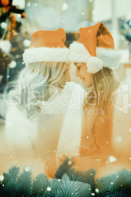 Composite image of festive mother and daughter smiling at each o
