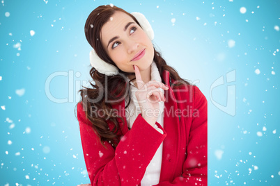 Composite image of smiling brunette in winter wear thinking