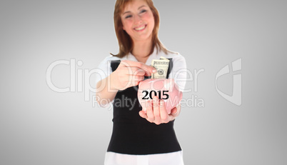 Composite image of woman putting money in a piggy bank