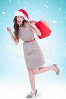 Composite image of festive brunette in dress holding shopping ba
