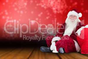 Composite image of santa sits next to his bag