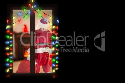 Composite image of santa carrying sack of gifts