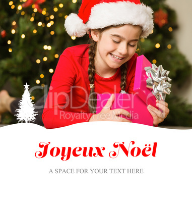 Composite image of little girl opening a gift at christmas