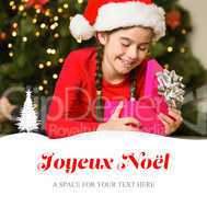 Composite image of little girl opening a gift at christmas