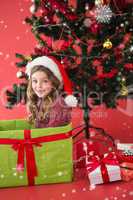 Composite image of festive little girl sitting in large gift