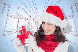 Composite image of excited brunette in santa hat showing gift
