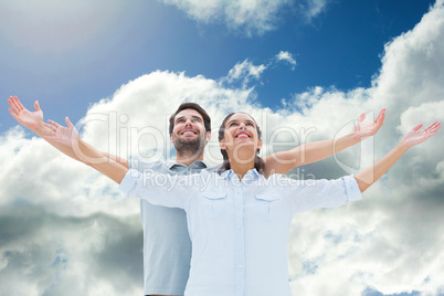 Composite image of cute couple standing with arms out