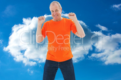 Composite image of mature man in orange tshirt cheering