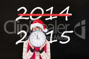 Composite image of festive brunette holding a clock