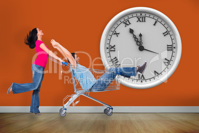 Composite image of young couple having fun with shopping cart