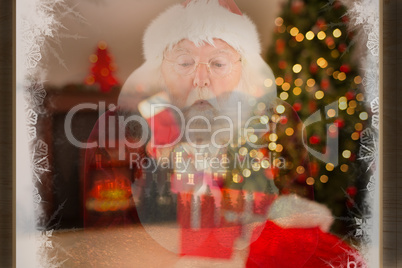 Composite image of santa claus blows something away