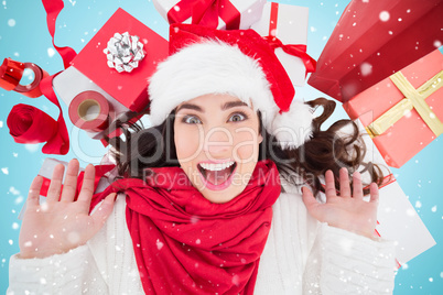 Composite image of excited brunette lying near christmas present