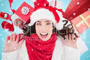 Composite image of excited brunette lying near christmas present