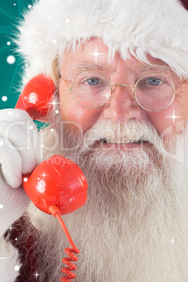 Composite image of santa on his red phone