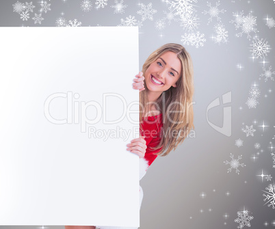 Composite image of pretty santa girl smiling at camera behind po