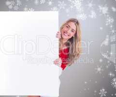 Composite image of pretty santa girl smiling at camera behind po