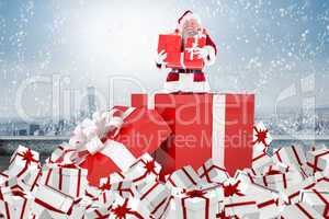 Composite image of santa standing in large gift