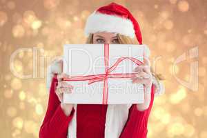 Composite image of blonde woman hiding behind a gift