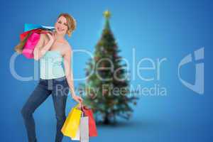 Composite image of smiling blonde woman standing with shopping b